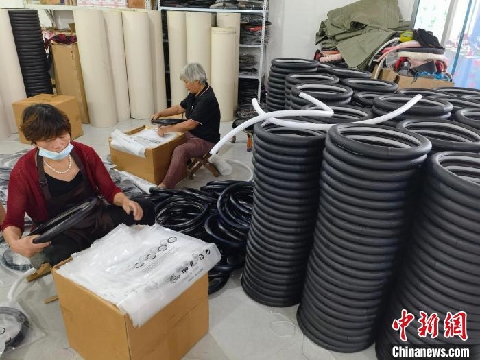 圖為村民在汽車飾品企業(yè)生產(chǎn)車間中工作?！巫雍?攝