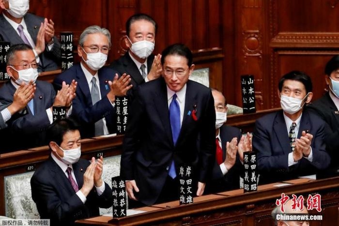 當?shù)貢r間10月4日，日本自民黨總裁岸田文雄經(jīng)過眾院全體會議的首相指名選舉成為第100任首相。圖為岸田文雄（中）起身致謝。