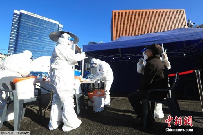 資料圖：韓國首爾，醫(yī)務(wù)人員對市民進(jìn)行新冠病毒檢測。