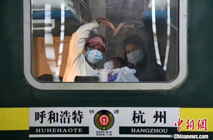 圖為登上轉(zhuǎn)運(yùn)火車的游客向額濟(jì)納比心?！⊥趵?攝