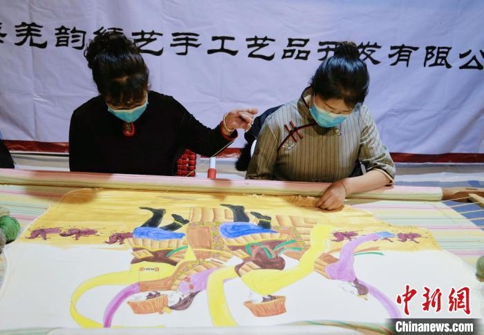 圖為皮繡藝人在市集上“秀”指尖技藝?！●R銘言 攝