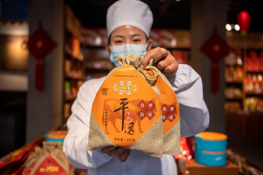 1月27日，在平遙古城南大街的一家平遙牛肉店內(nèi)，工作人員展示一款牛肉產(chǎn)品。新華社記者 楊晨光 攝