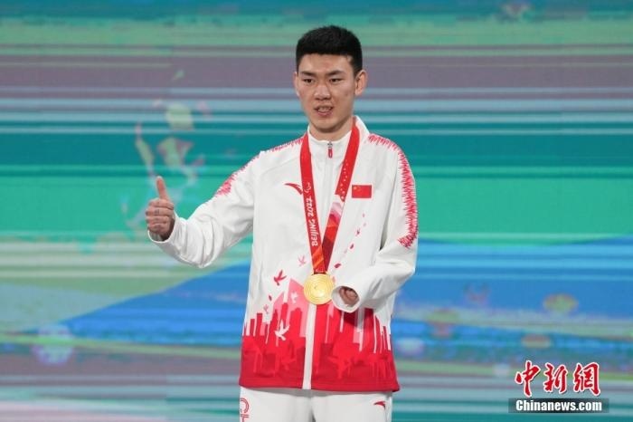 3月6日，梁景怡在延慶頒獎廣場領(lǐng)獎臺上豎起大拇指。當(dāng)日，在國家高山滑雪中心舉行的北京2022年冬殘奧會殘奧高山滑雪男子超級大回轉(zhuǎn)—站姿決賽中，中國選手梁景怡奪得冠軍。 <a target='_blank' href='/'>中新社</a>記者 楊華峰 攝