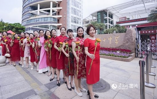 6月7日一早，廈門雙十中學考生家長們身穿旗袍，手拿向日葵在考場外為孩子加油打氣，寓意“旗開得勝，一舉奪魁”。人民網(wǎng)記者 陳博攝