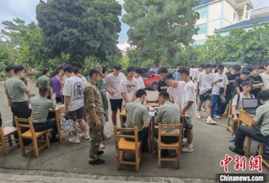 專武干部在發(fā)放兵役登記證。韋碩 攝