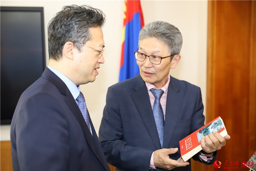 其米德策耶（右一）向李峙介紹翻譯成果。人民網(wǎng)記者 霍文攝