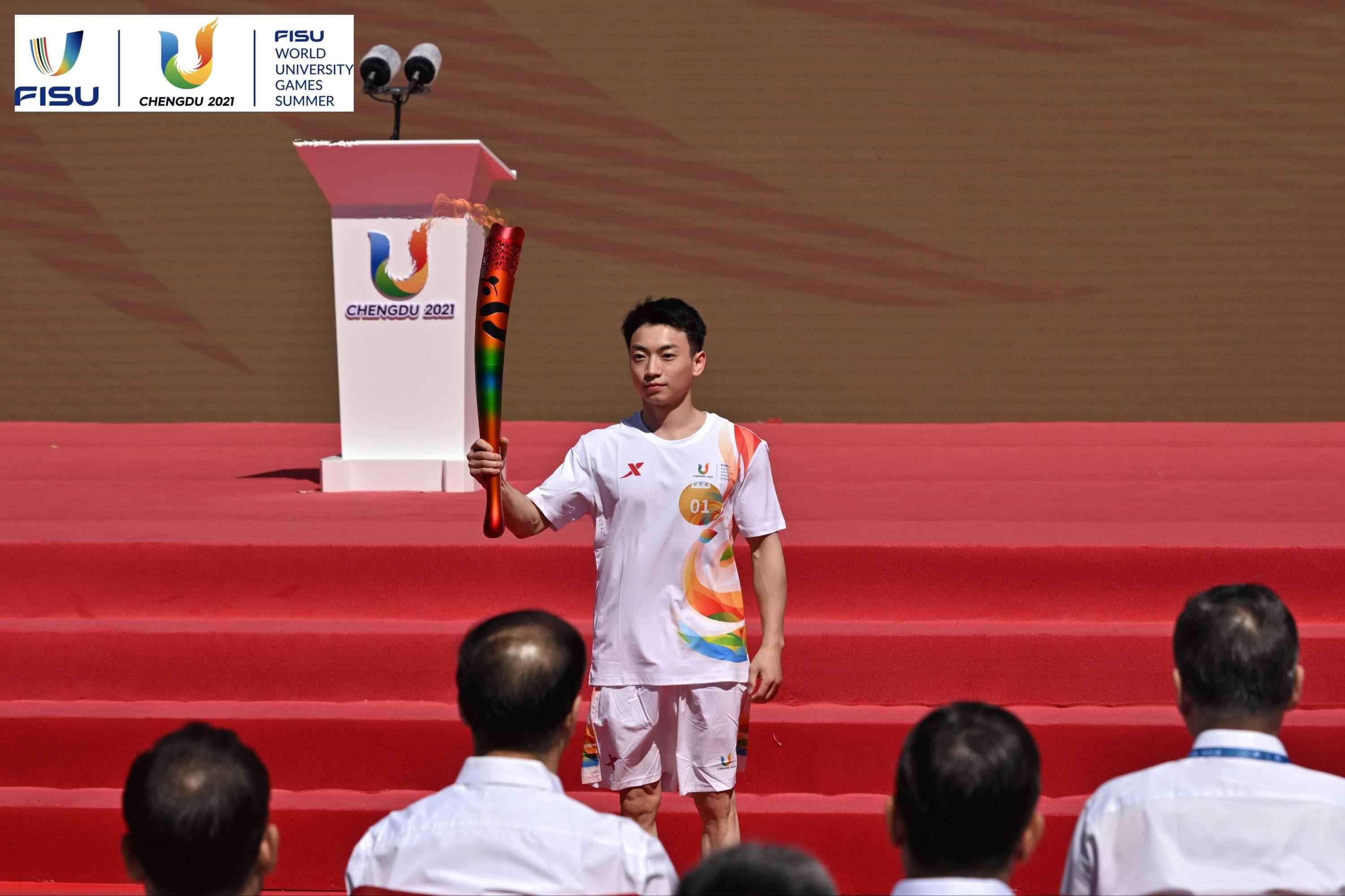 成都大運會火炬手、奧運冠軍鄒敬園高舉火炬。 圖片來源：成都大運會執(zhí)委會供圖