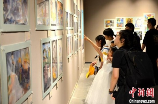 圖為家長帶著孩子參觀展覽。呂明 攝