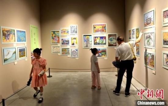 圖為家長帶著孩子參觀展覽。呂明 攝