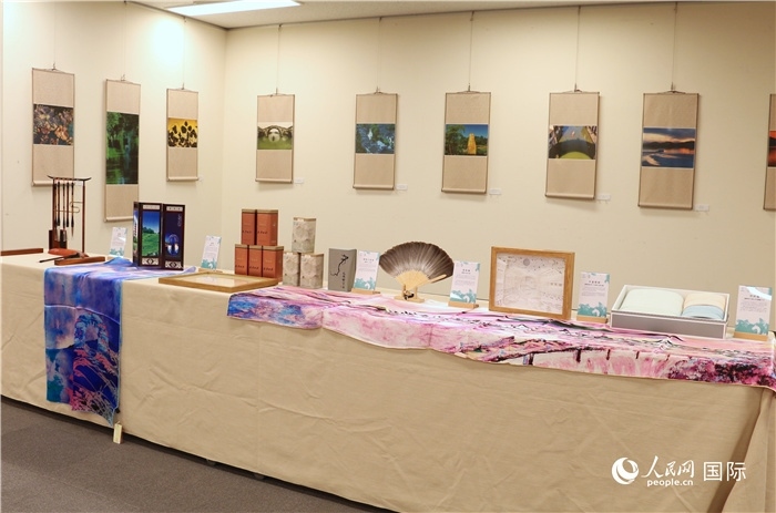 現(xiàn)場展出的馮學敏攝影作品與湖州市特色工藝品。（人民網(wǎng) 許可攝）