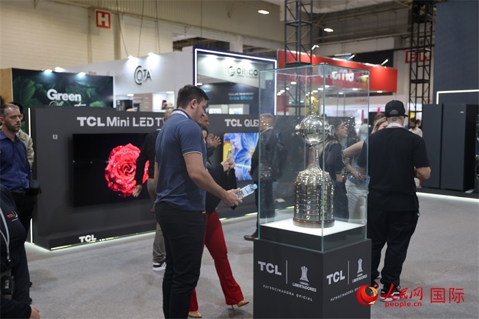 參觀者在TCL展臺前觀看南美解放者杯獎杯，據(jù)介紹，TCL是南美解放者杯（2023—2026賽季）全球官方合作伙伴。（人民網(wǎng)記者 時元皓攝）