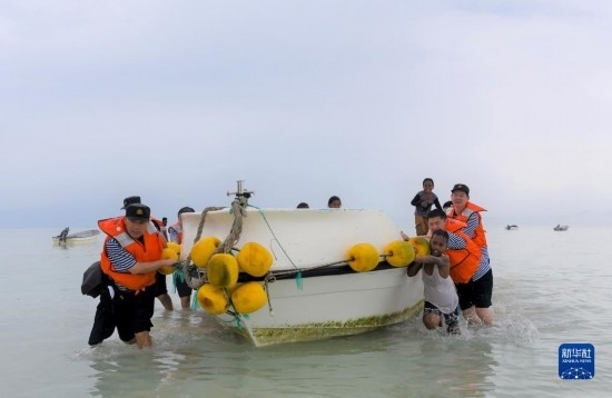 7月21日，中國海軍“和平方舟”號醫(yī)院船醫(yī)護(hù)人員涉水登島，前往基里巴斯一診療點(diǎn)。新華社記者 黎云 攝
