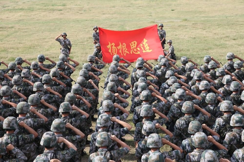 ↑“楊根思連”官兵執(zhí)行任務(wù)前向連旗宣誓（資料照片）。新華社發(fā)
