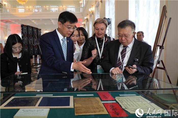 中俄圖書館論壇嘉賓共同參觀由俄羅斯國(guó)立列寧圖書館舉辦的館藏中國(guó)古籍善本圖書展。人民網(wǎng)記者 隋鑫攝）