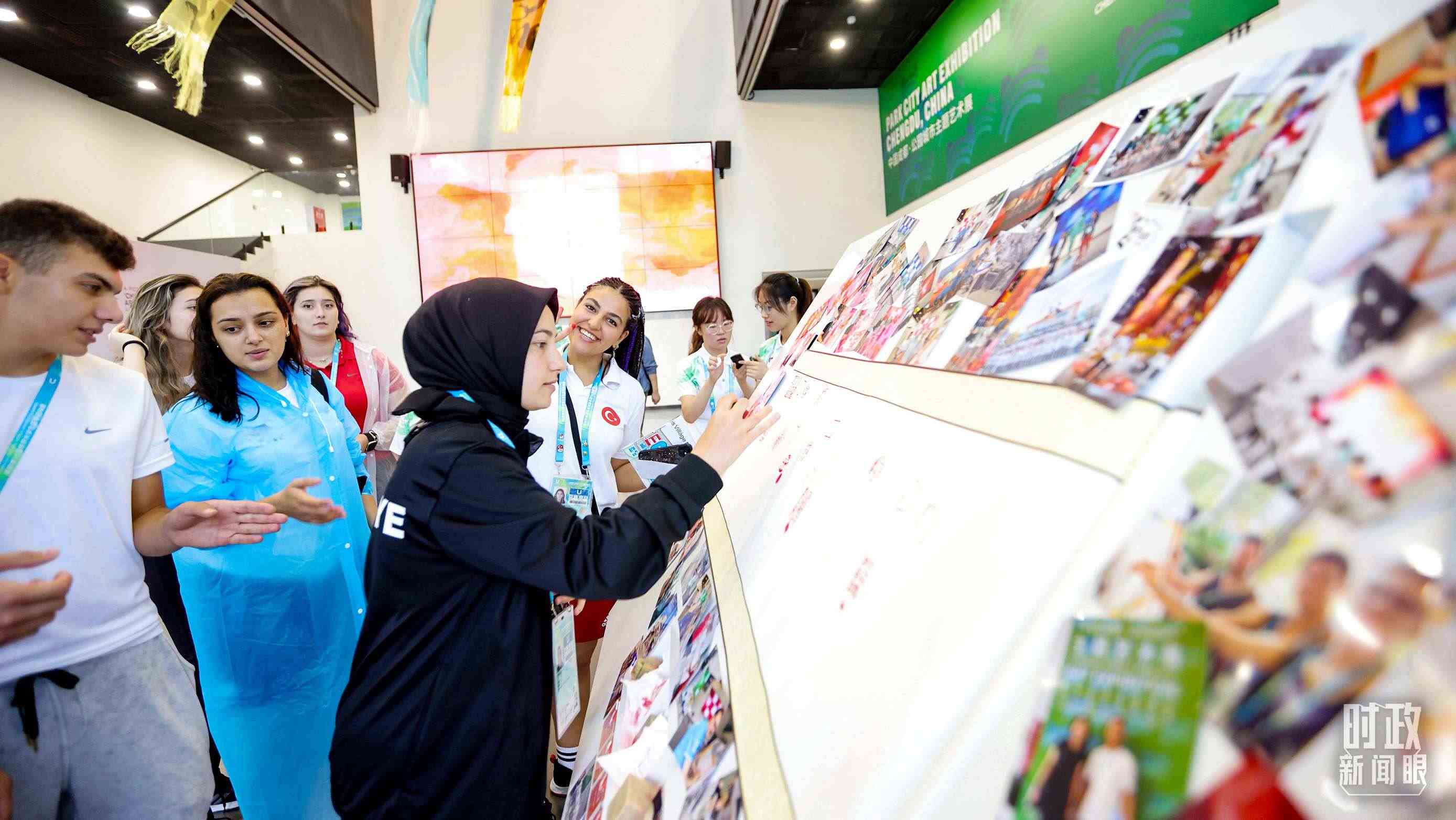 各國青年運動員正在參觀成都大運村內(nèi)的“雪山下的公園城市，煙火里的幸福成都”主題藝術(shù)展。（總臺央視記者魏幫軍拍攝）