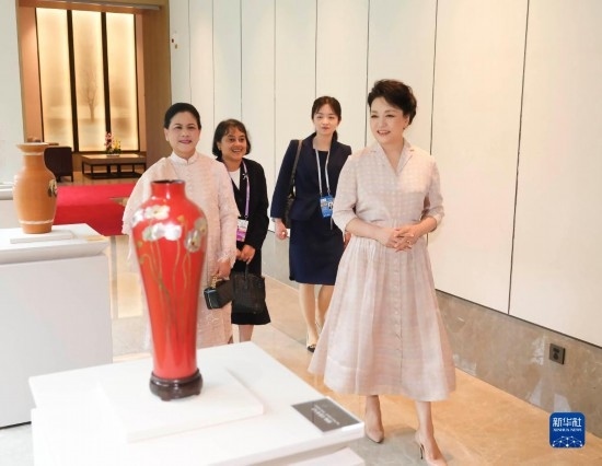 7月27日下午，國家主席習(xí)近平夫人彭麗媛在四川成都會見陪同印度尼西亞總統(tǒng)佐科來華出席第31屆世界大學(xué)生夏季運動會開幕式并訪華的總統(tǒng)夫人伊莉亞娜。這是彭麗媛和伊莉亞娜欣賞成都特色非遺工藝品。新華社記者 丁林 攝