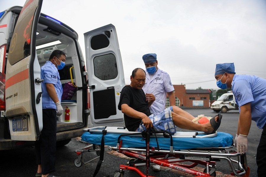 8月1日，在北京市門頭溝區(qū)妙峰山鎮(zhèn)妙峰山民族學(xué)校臨時(shí)安置點(diǎn)，北京急救中心工作人員在轉(zhuǎn)運(yùn)一名受傷村民。新華社記者 鞠煥宗 攝