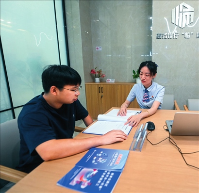 在杭州市臨安區(qū)政務服務中心的“為企服務中心”，黨員志愿者（右）解答企業(yè)主的疑問（2023年7月7日攝）。徐昱攝/本刊