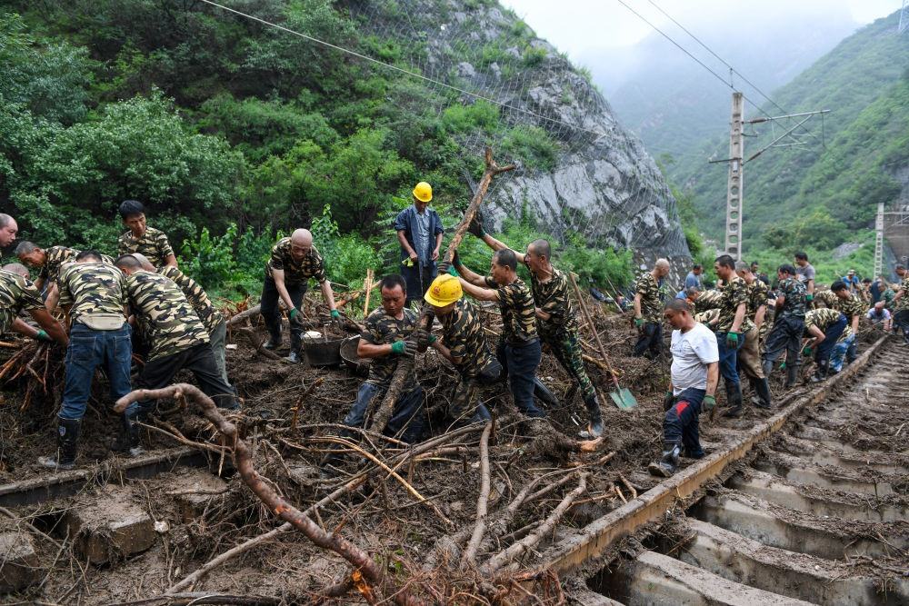 8月1日，在北京市門頭溝區(qū)水峪嘴村附近一段被阻斷的鐵路線上，中鐵六局工作人員在清理軌道上的雜物，全力恢復(fù)交通。新華社記者 鞠煥宗 攝