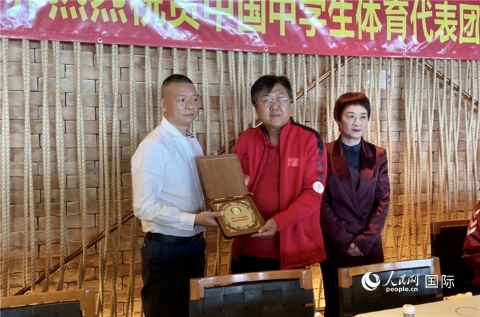 巴西中國和平統(tǒng)一促進會會長王俊曉向中國中學(xué)生體育代表團團長劉立新贈送紀(jì)念品。人民網(wǎng)記者 宋亦然攝