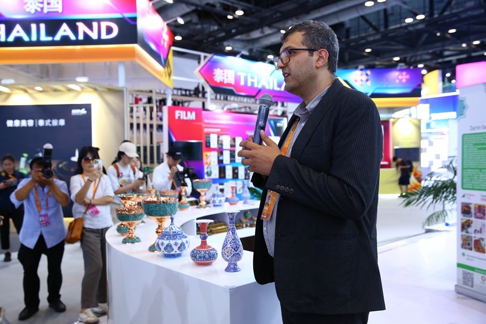 9月1日，參展商在國家會議中心向媒體記者介紹展臺信息。新華社記者 孫瑋彤 攝