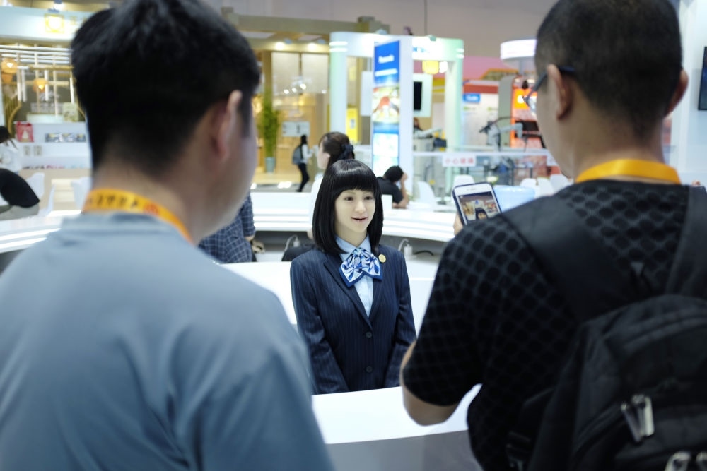 9月1日，媒體記者在國家會議中心與服務(wù)機器人互動。新華社記者 劉夢琪 攝