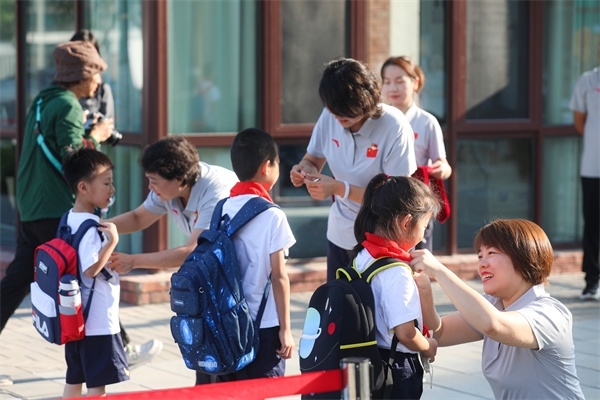 8月30日，雄安史家胡同小學(xué)學(xué)生體驗(yàn)學(xué)校生活。老師為學(xué)生佩戴校徽。