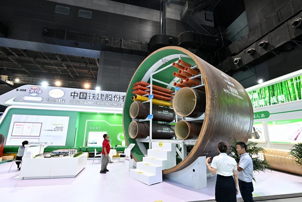 9月2日，在國(guó)家體育館舉行的服貿(mào)會(huì)環(huán)境服務(wù)專題展上，客商在中國(guó)鐵建展位竹纏繞管廊旁了解信息。新華社記者 李鑫 攝