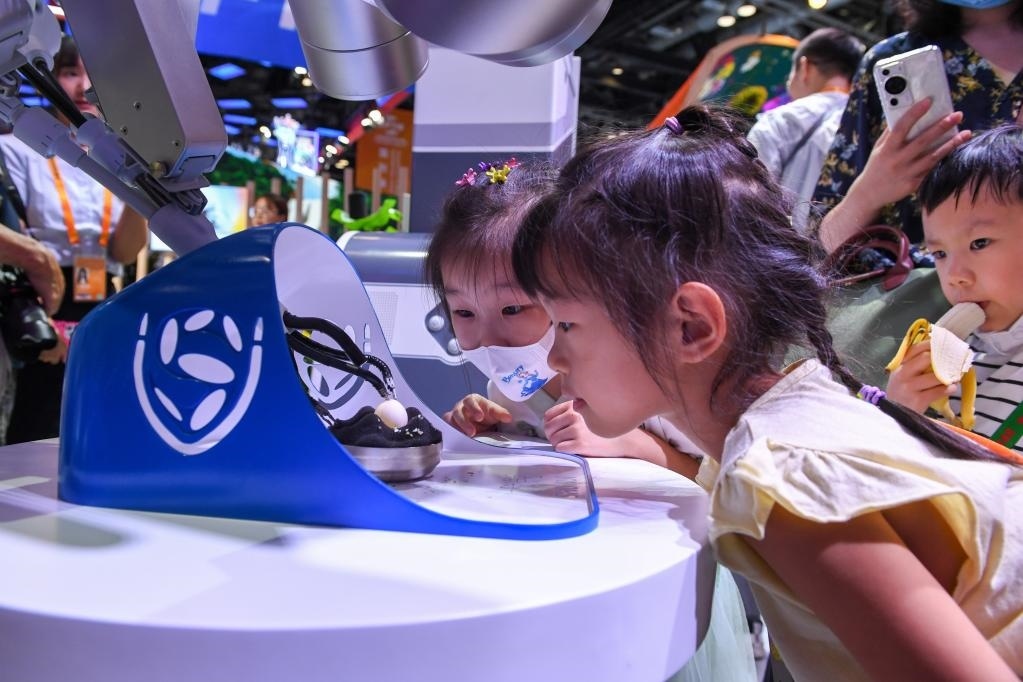 9月3日，幾名小朋友在國家會議中心觀看單孔腔鏡手術(shù)機器人展示。新華社記者 鞠煥宗 攝