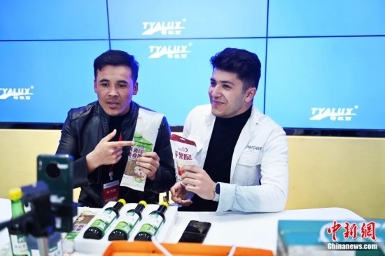 2023年3月，甘肅省慶陽市環(huán)縣電商創(chuàng)業(yè)孵化基地內(nèi)，來自蘭州文理學(xué)院的塔吉克斯坦留學(xué)生正在協(xié)助主播直播帶貨當(dāng)?shù)剞r(nóng)特產(chǎn)品。李亞龍 攝