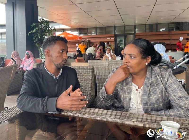 約漢斯（圖左）與德貝拉在友誼廣場(chǎng)咖啡廳交談。人民網(wǎng)記者 趙艷紅攝