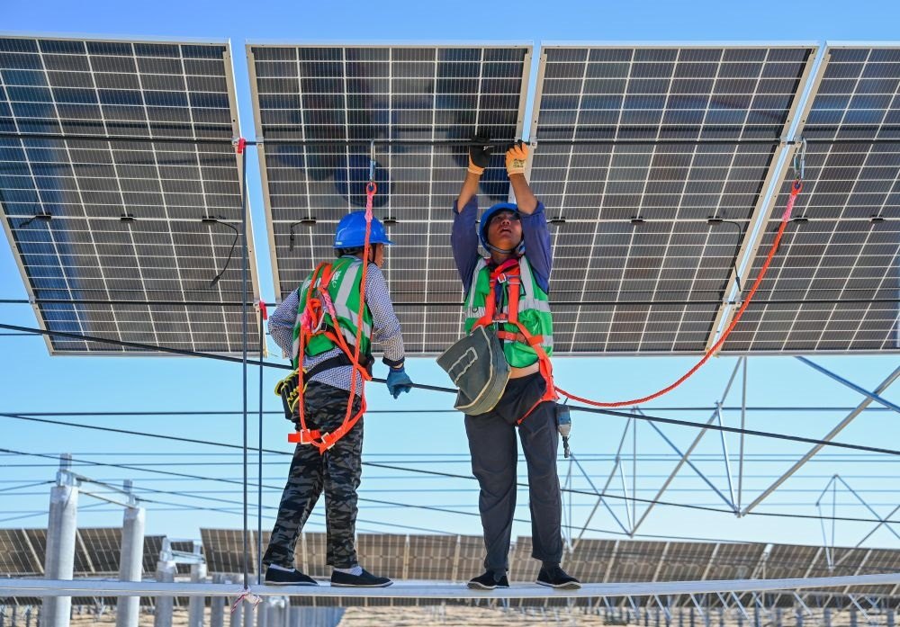 2023年7月22日，工人在位于內(nèi)蒙古杭錦旗庫布其沙漠億利生態(tài)示范區(qū)的蒙西基地庫布其200萬千瓦光伏治沙項目工地安裝光伏板。新華社記者 劉磊 攝