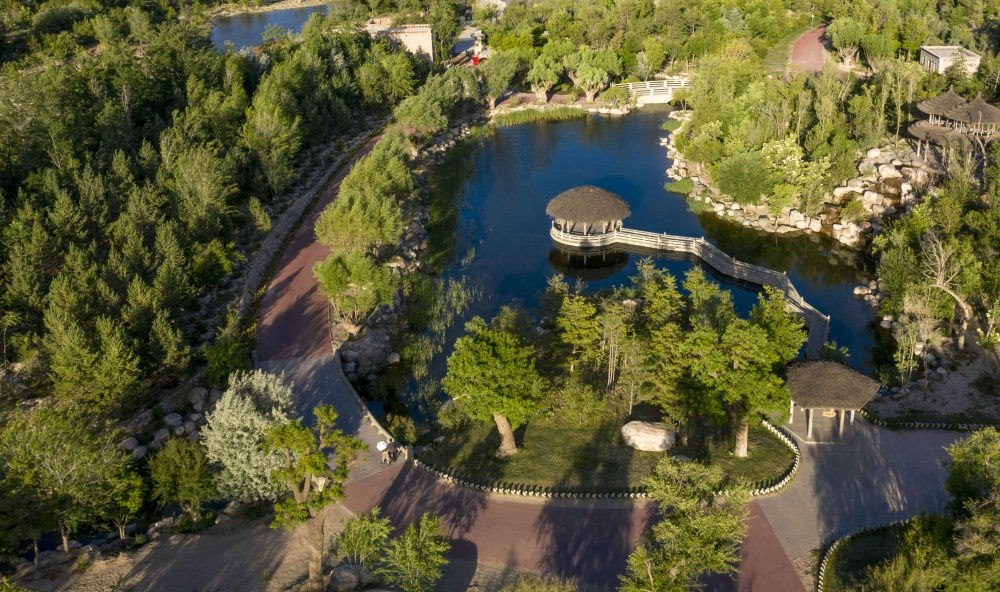 坐落在寧夏銀川市賀蘭山腳下的賀蘭山運動休閑公園（2021年5月27日攝，無人機照片）。這里曾是一片砂石采礦塌陷區(qū)，當?shù)赝ㄟ^植被景觀再造、水系建設(shè)、現(xiàn)代管網(wǎng)鋪建等手段，重新利用廢石、廢坑及各類廢棄建筑材料，把這里變成一座免費開放的主題公園。新華社記者 馮開華 攝