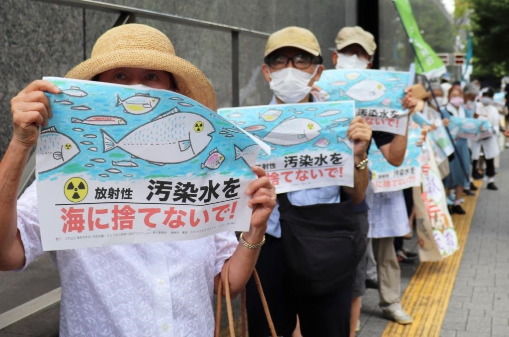 8月24日，日本民眾手持“不要將污染水扔進大?！钡葮苏Z在東京電力公司總部前集會，抗議日本政府和東電公司無視民意啟動核污染水排海。新華社記者楊光攝