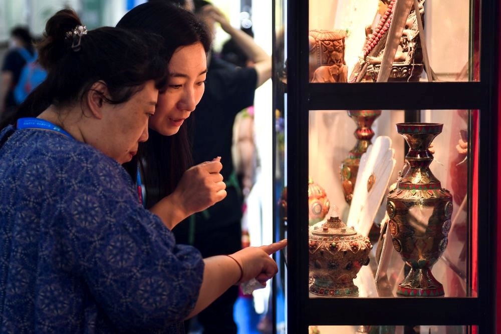 △2023年8月24日，參觀者在第十四屆中國—東北亞博覽會現(xiàn)場選購尼泊爾特色商品。