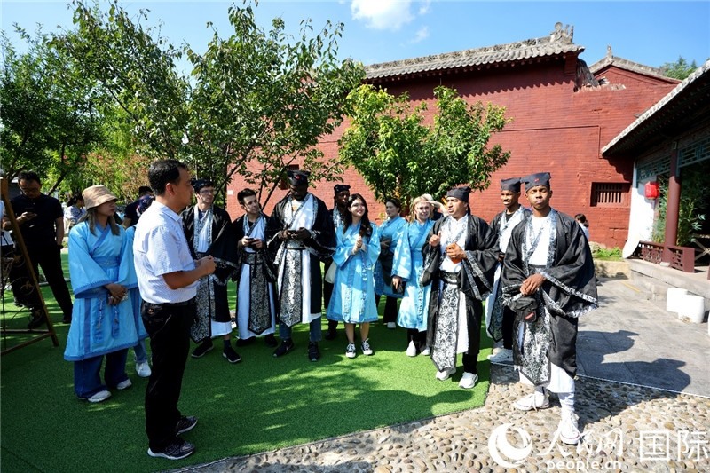 圖為選手們聽導(dǎo)游講解。人民網(wǎng) 盧鵬宇攝