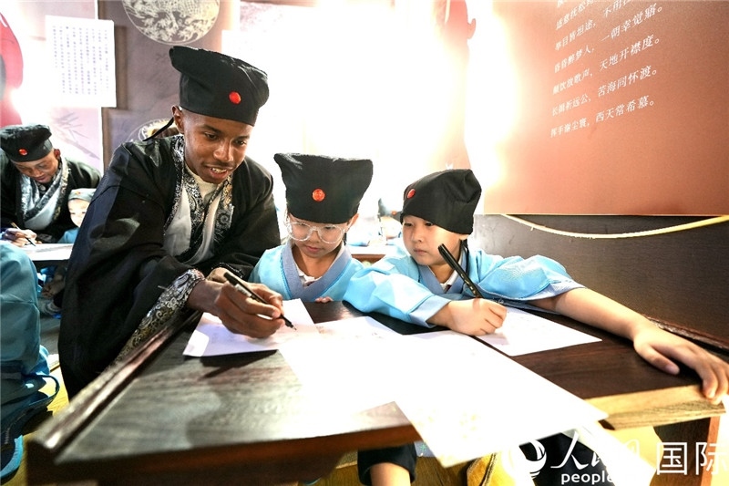 圖為選手與同學(xué)們一起寫書法。人民網(wǎng) 盧鵬宇攝