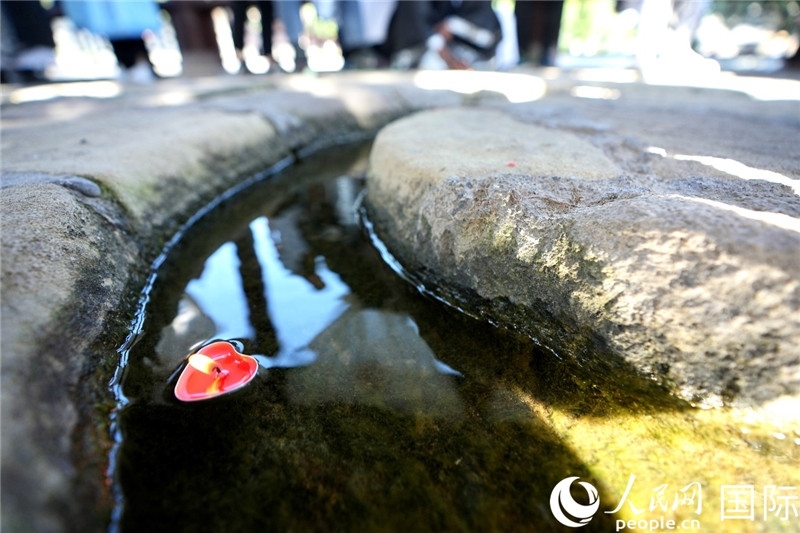 圖為水渠里流過的“桃心”蠟燭。人民網(wǎng) 盧鵬宇攝