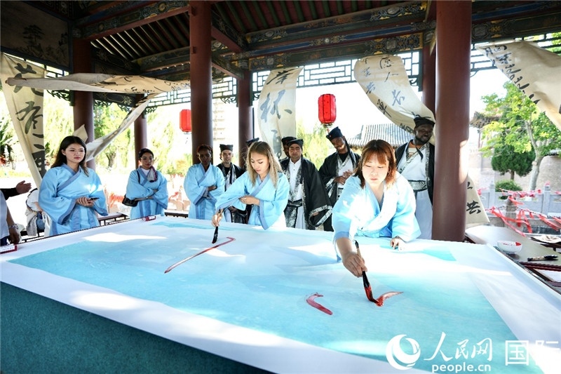 選手們提筆書寫“家園”二字。人民網(wǎng) 盧鵬宇攝