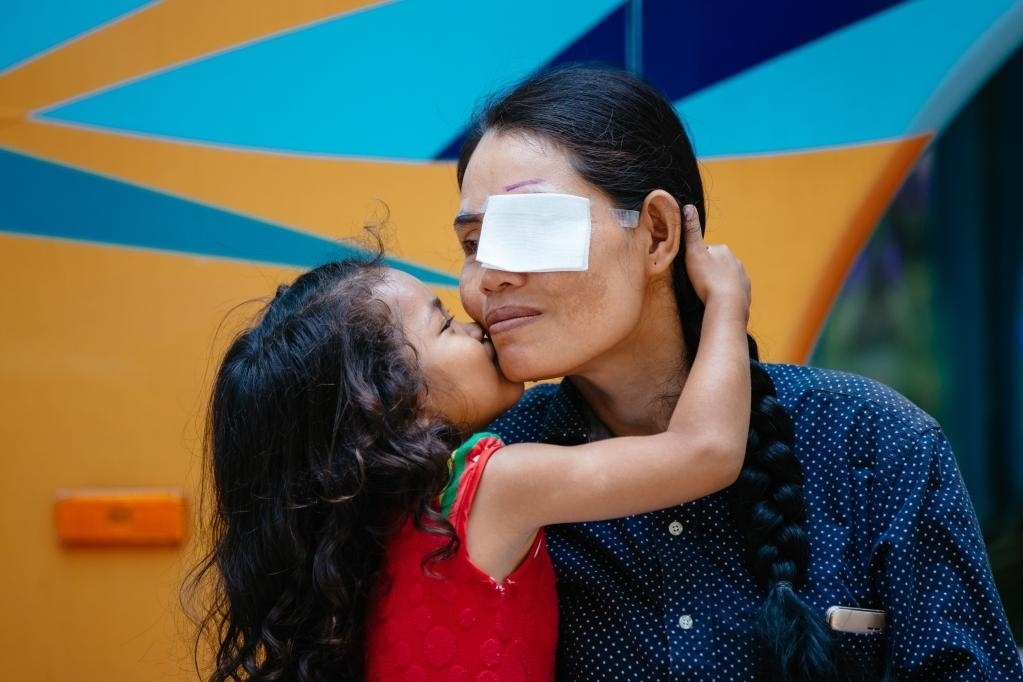 2019年3月15日，在柬埔寨磅湛省醫(yī)院，即將接受白內障手術的患者孫美樂接受女兒的親吻祝福。在接受了中國醫(yī)療隊的白內障義診手術后，她的視力逐步恢復，生活有了新的光明和希望。