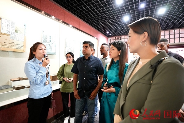 選手們認真聆聽導游講解。人民網(wǎng) 盧鵬宇攝