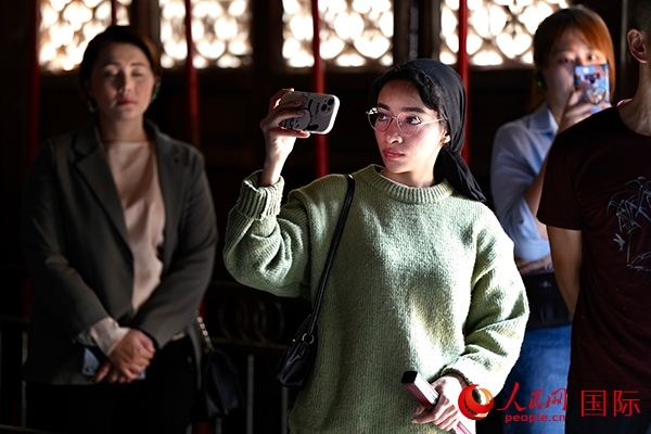 選手顏青（蘇丹）用手機記錄所見所感。人民網(wǎng) 盧鵬宇攝