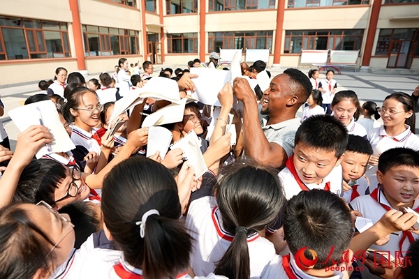 孩子們和選手互動(dòng)簽名。人民網(wǎng) 盧鵬宇攝