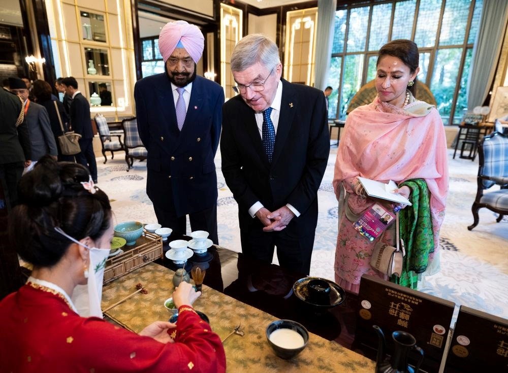 △歡迎宴會前，亞奧理事會代理主席辛格和夫人維尼塔、國際奧委會主席巴赫欣賞非遺展示。