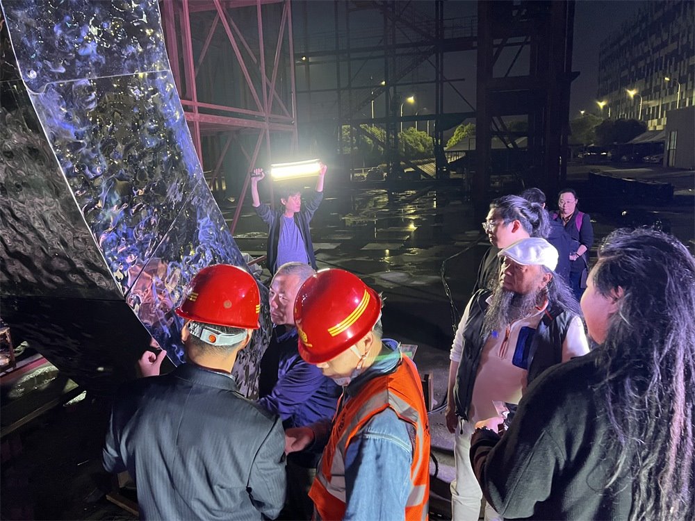 林崗（右二）和團(tuán)隊查看主火炬制作進(jìn)度。受訪者供圖