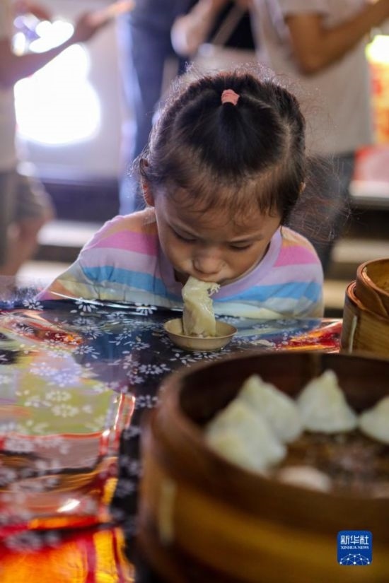 9月27日，小朋友在南翔小籠長(zhǎng)街宴上品嘗南翔小籠。