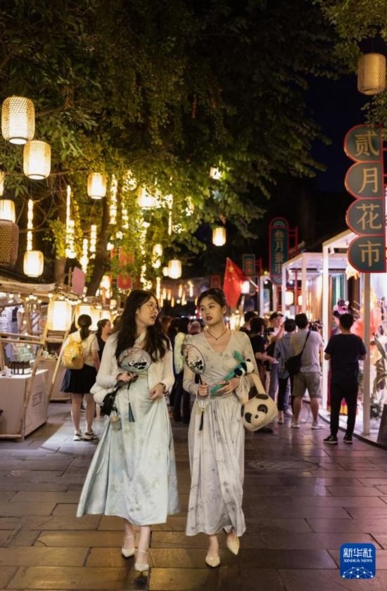 在成都寬窄巷子，兩位來(lái)自安徽的游客在新“十二月市”街區(qū)游覽（9月29日攝）。