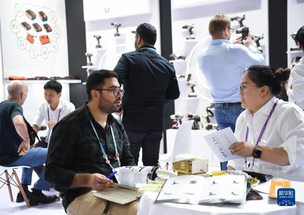 10月15日，在一家電動(dòng)工具展臺(tái)，外國采購商在洽談業(yè)務(wù)。新華社記者 鄧華 攝