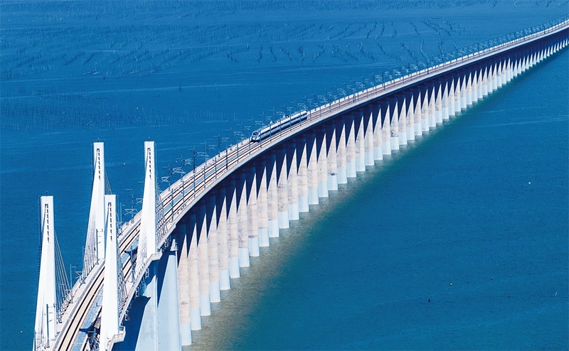 2023年9月28日，中國首條時速350公里跨海高鐵——福廈高鐵正式開通運營。圖為一列運行試驗車組駛過福廈高鐵湄洲灣跨海大橋（9月19日攝，無人機照片）。 新華社記者 魏培全/攝