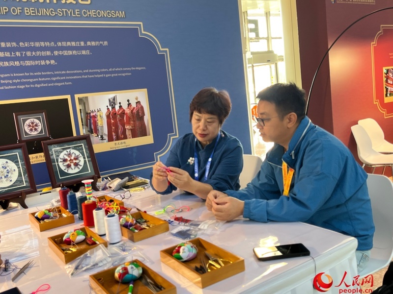 記者在新聞中心非遺傳承人展區(qū)進行體驗。人民網(wǎng)記者 杜燕飛攝